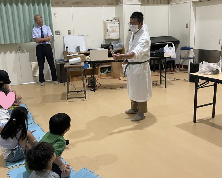 実験する先生と、それを見る子供達